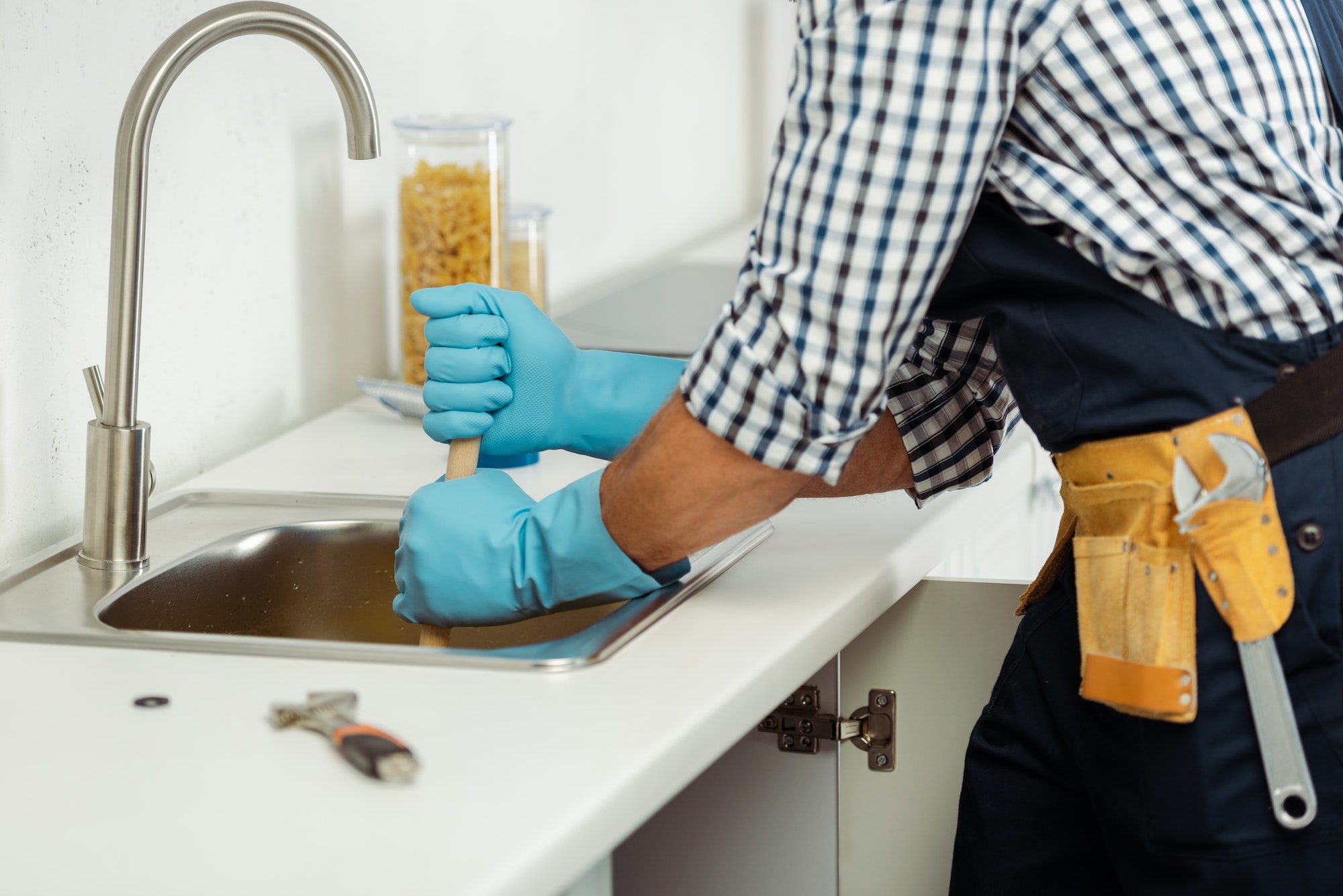 cropped-view-of-plumber-in-tool-belt-and-rubber-gloves-cleaning-blockage-of-kitchen-sink.jpg