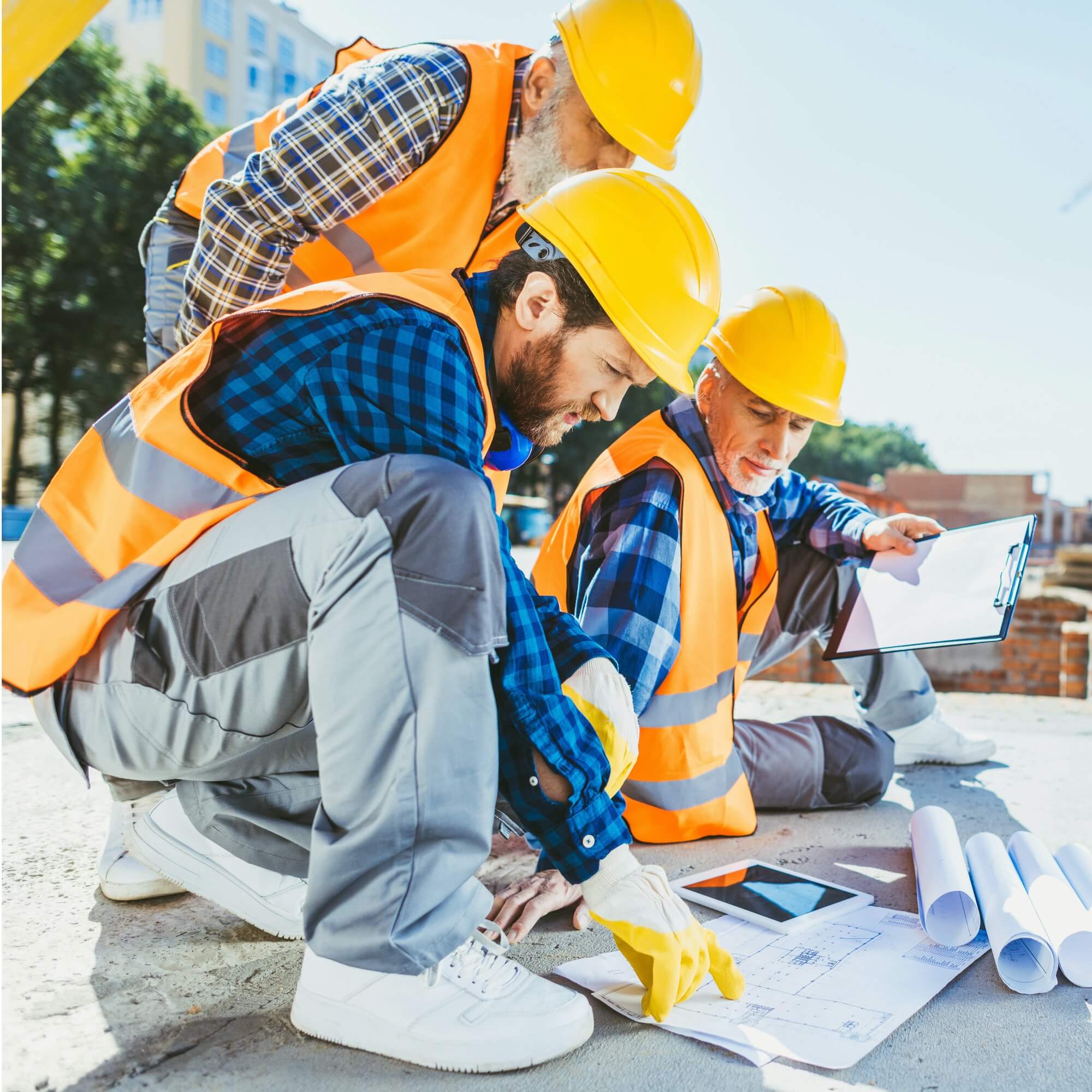 handsome-construction-workers-sitting-on-concrete-at-construction-site-discussing-building-plans-1.jpg