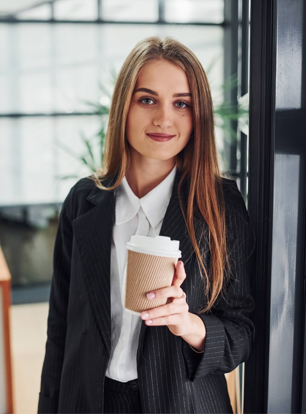 woman-in-formal-clothes-standing-indoors-in-the-of-RL3HSGC.jpg