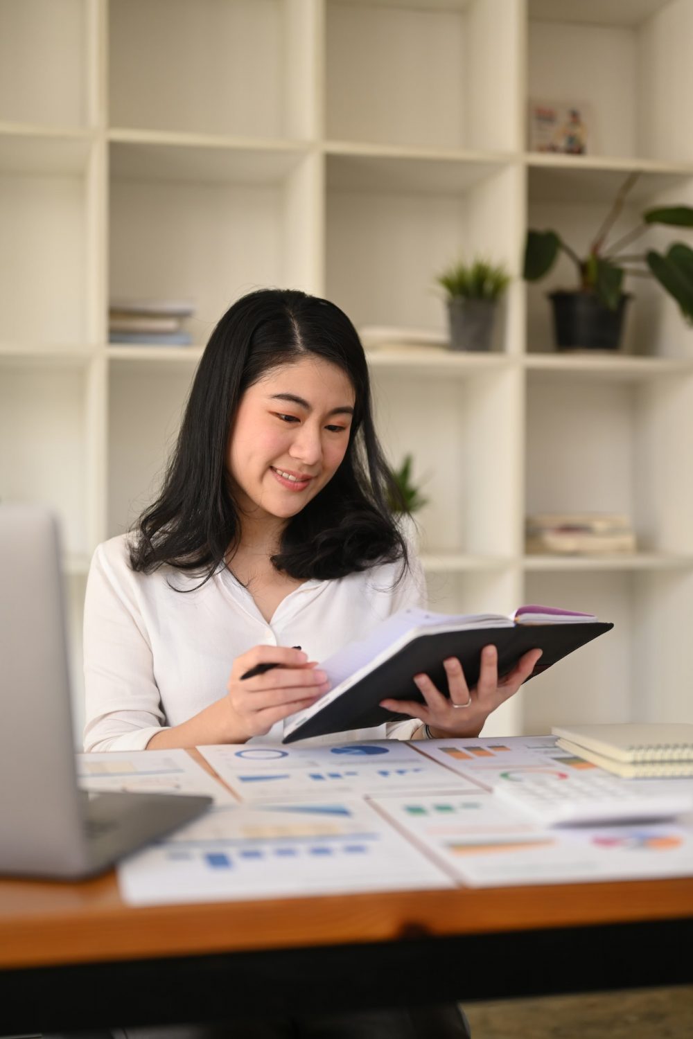 attractive-young-businesswoman-working-with-laptop-and-document-at-corporate-office--e1670796374357.jpg